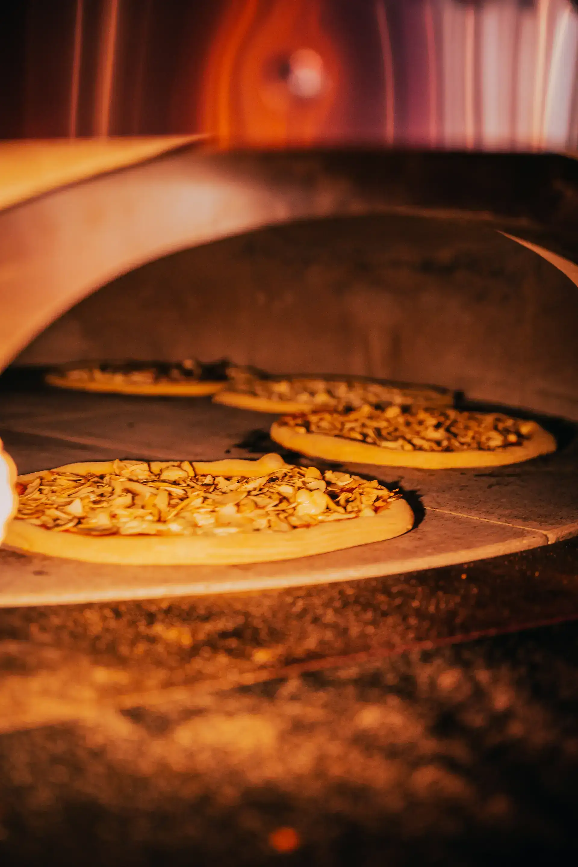 Photo du four a pizza, avec des pizzas qui cuisent
